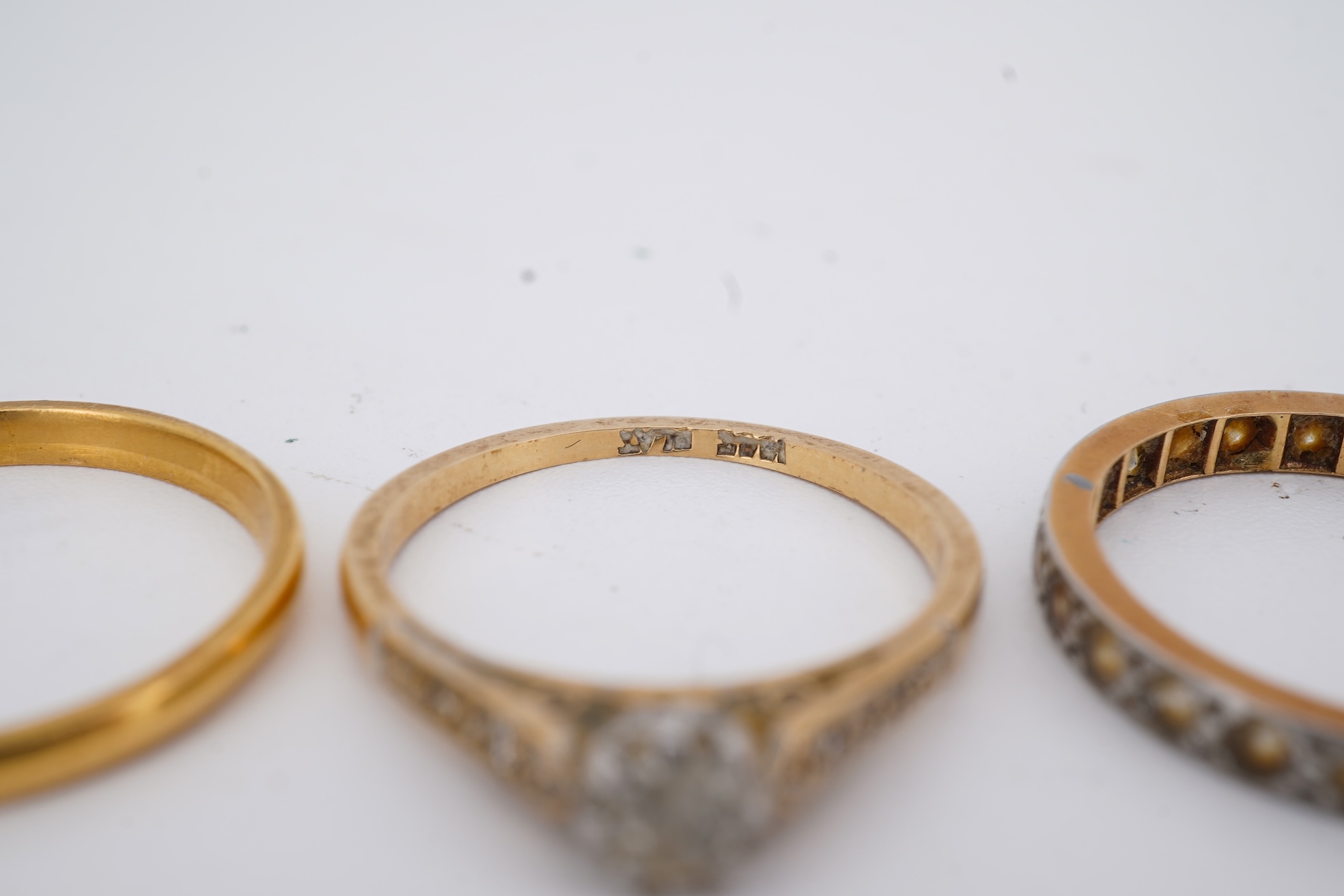 A 22ct wedding band, size M, 2 grams, an 18ct, plat and single stone diamond ring, a a modern 9ct gold, sapphire and diamond cluster ring and a yellow metal and white stone, eternity ring.